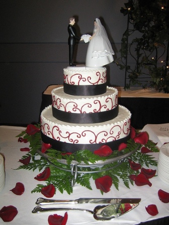  white cake with red and black decorations on the cake. red wedding cakes