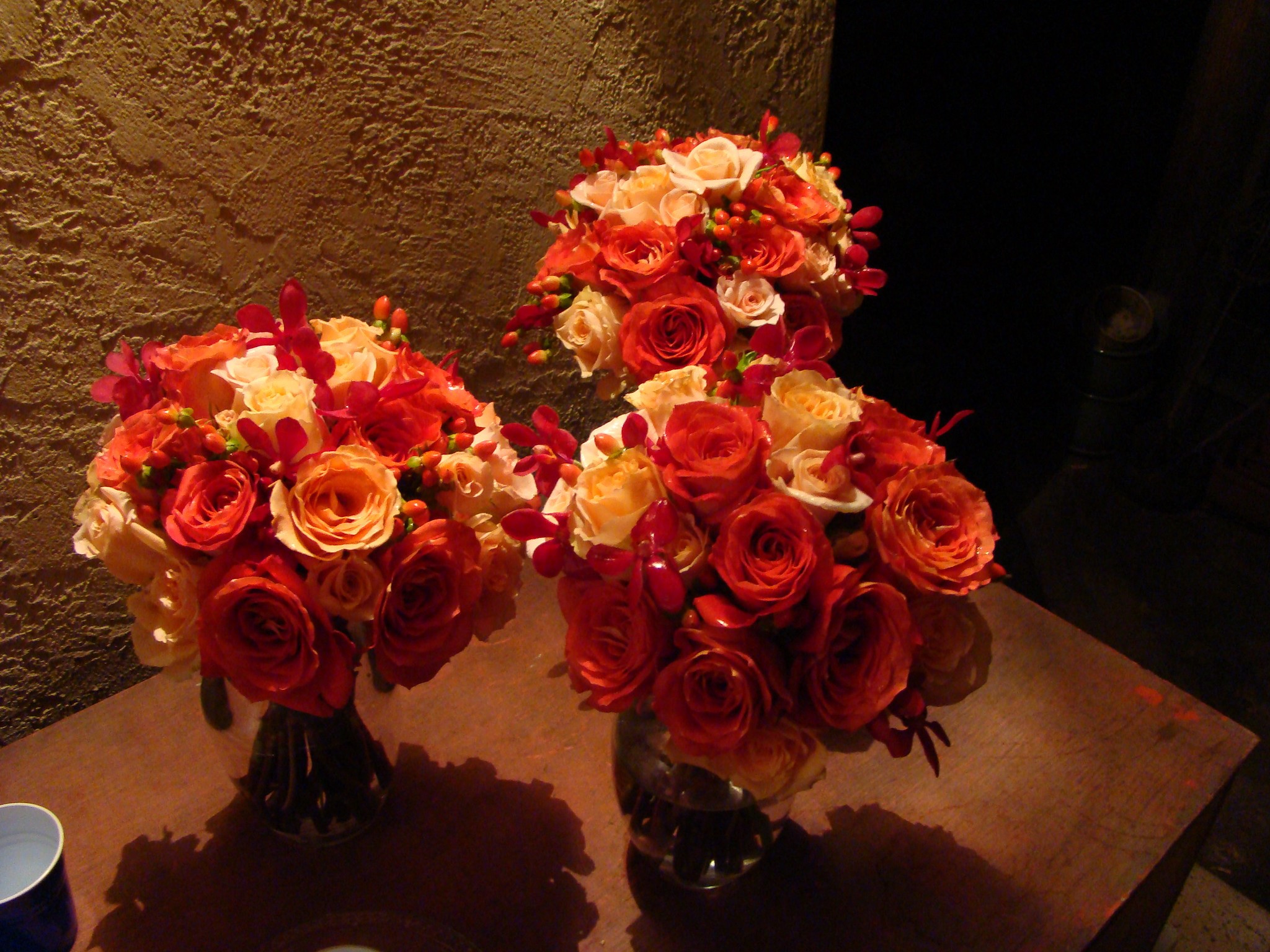 Trio of Gorgeous Red, Orange and Yellow Wedding Bouquets on Table