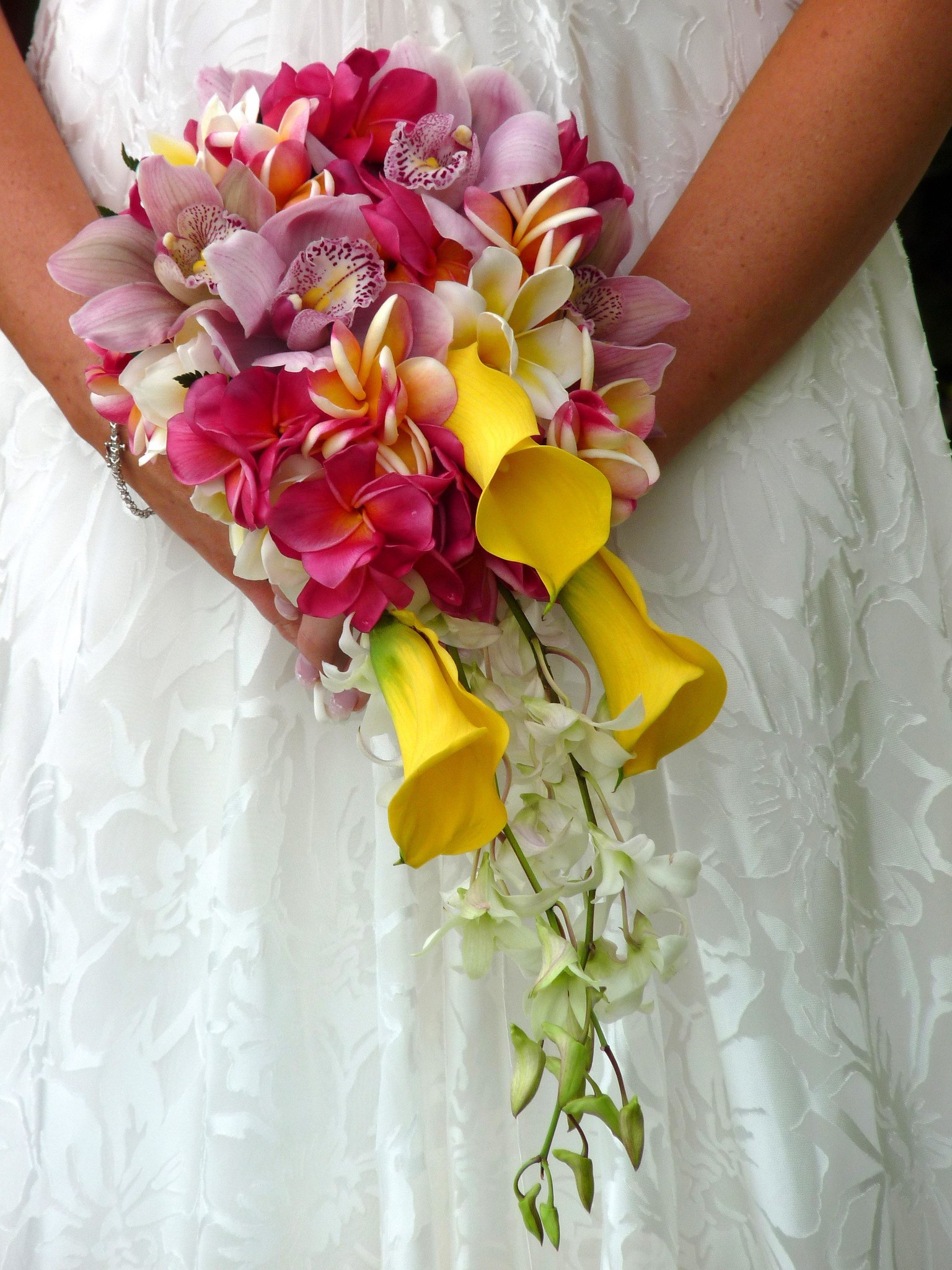 Bride holding stunning pink, purple, white and yellow orchid bouquet