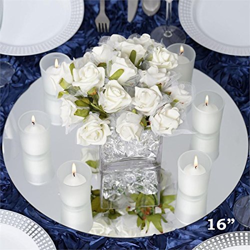 Beautiful white floral centerpiece surrounded by candles and placed on a circular mirror