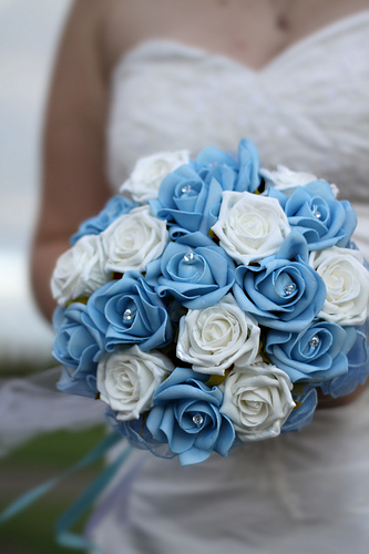 bride holding blue and white rose wedding bouquet