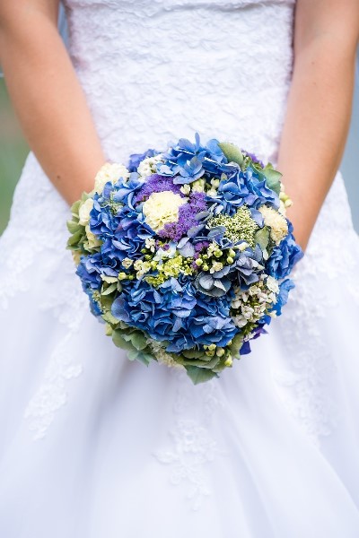 Bride Holding Beautiful blue, green and white wedding bouquet
