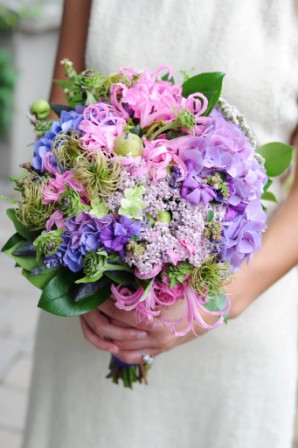 Bride holding colorful pink, purple, blue and green wedding bouquet