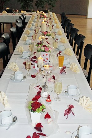 long white rectangle wedding table with red flower petals and white candles