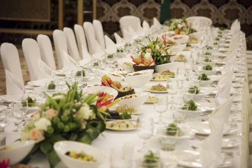 long white rectangle wedding table with white chairs and greenery