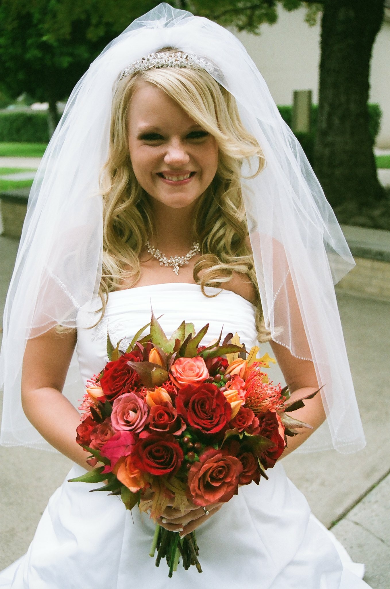 Bride Holding Beautiful Red and Orange Fall Bouquet