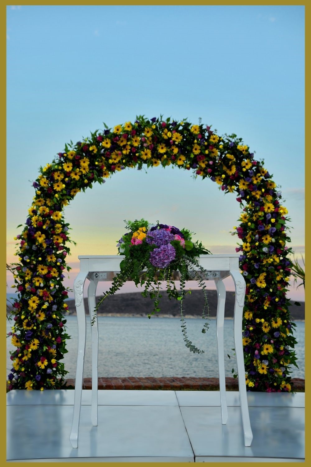 outdoor wedding alter with green and yellow floral wedding arch