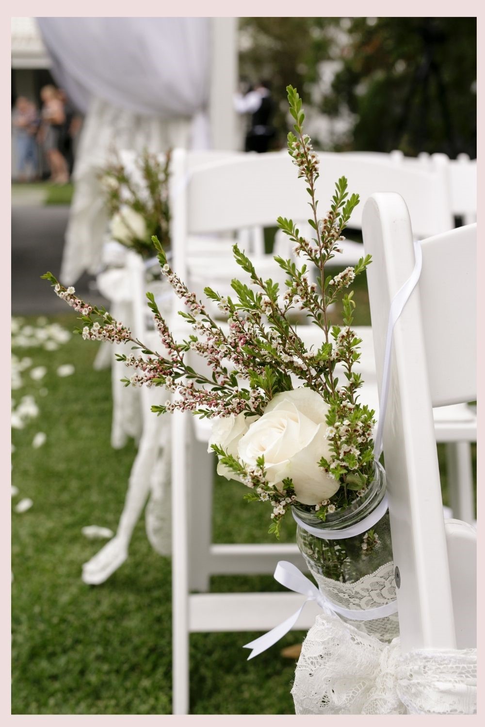 Outdoor Wedding Ceremony With White Chairs and White Flowers Hanging From Aisle Chairs - Pretty Floral Wedding Decoration